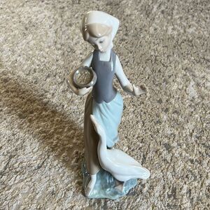 Lladro 1052 "Girl with Duck" feeding duck goose corn has a chip by the fingers